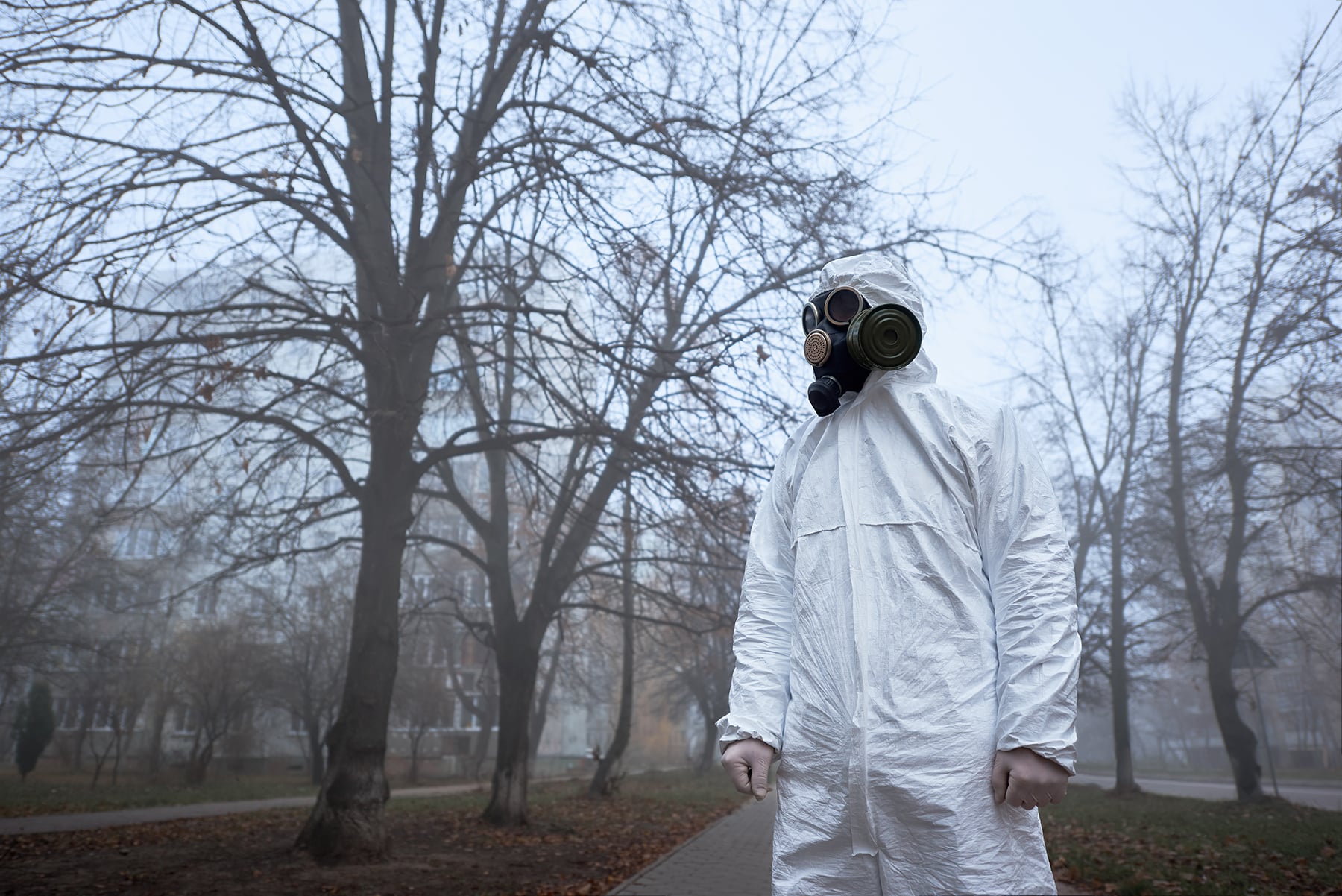Man in protective clothing outdoors, environmental disaster.